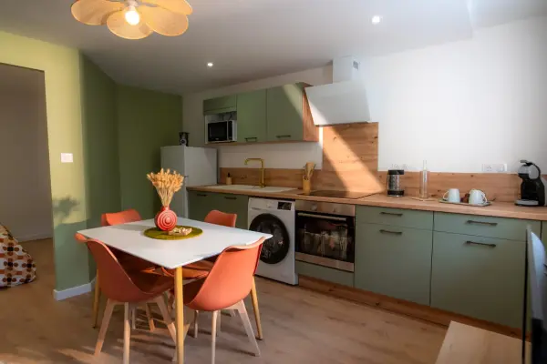 Vue d’ensemble de la cuisine ouverte : façades blanches et finitions nettes