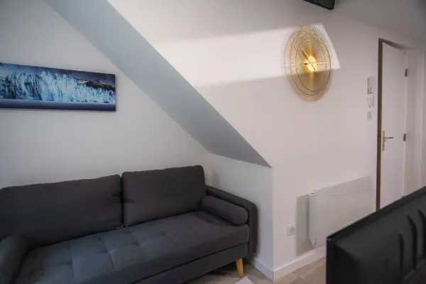 Séjour : canapé sous rampant, mur bleu clair et ambiance chaleureuse