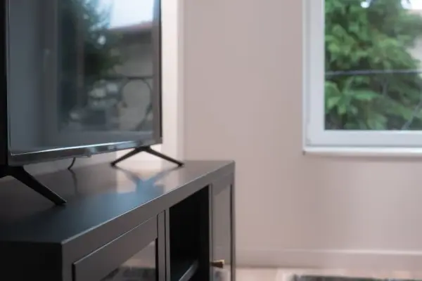 Vue serrée sur le coin TV, mobilier gris anthracite et finitions nettes