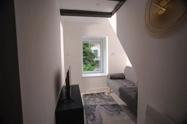 Vue vers le canapé depuis le couloir, transition fluide des espaces